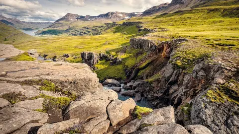 Blick auf grüne Täler und felsige Berge im Nordosten Islands bei Sommerwetter trendtours Reisen-placeholder